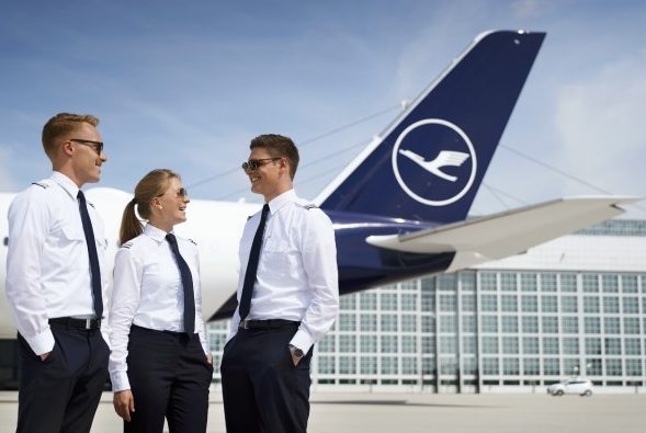 Flugschüler der Lufthansa stehen auf dem Flugfeld vor einem Lufthansa Flieger